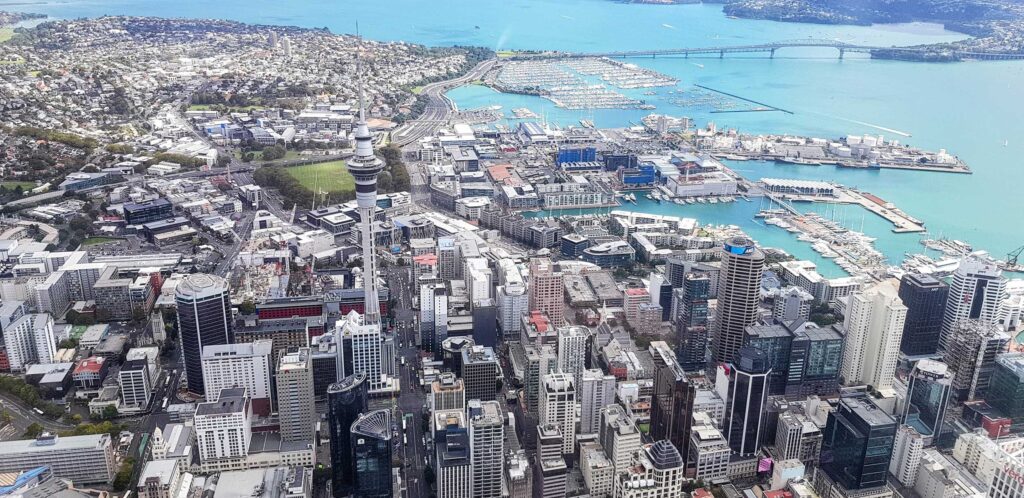 Aerial view of Auckland CBD, harbour, and Sky Tower, representing a major New Zealand business hub for social media marketing and management